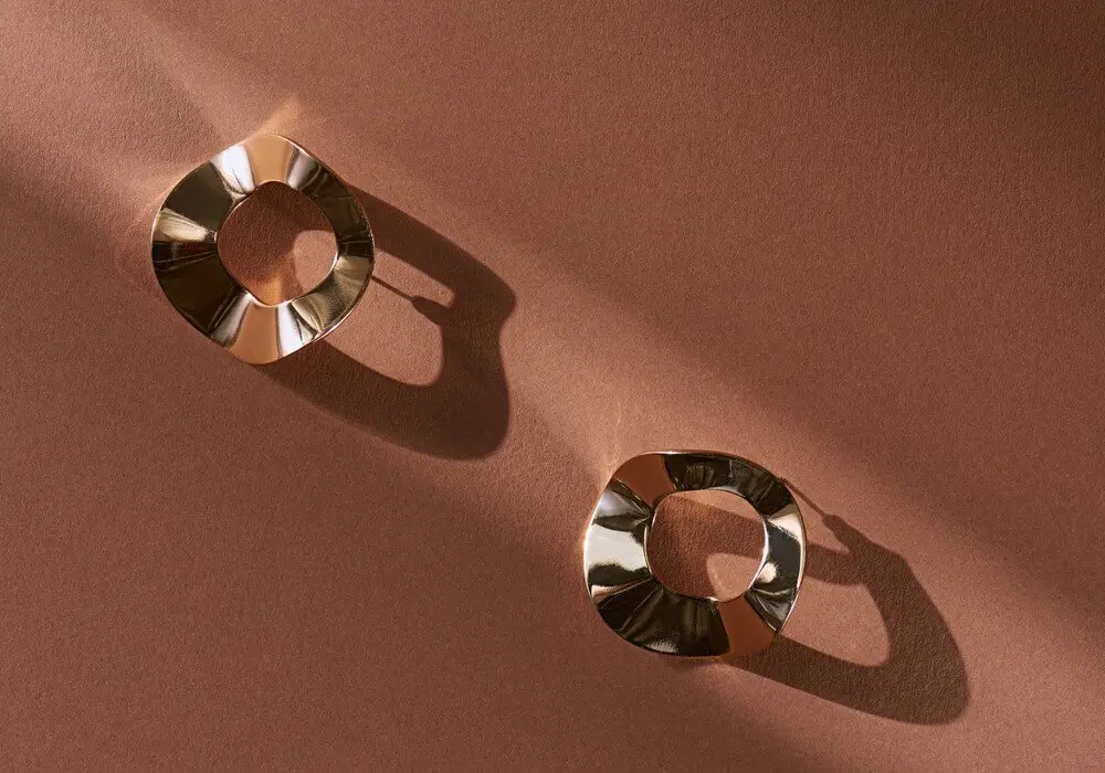 Two gold rings on a warm brown background