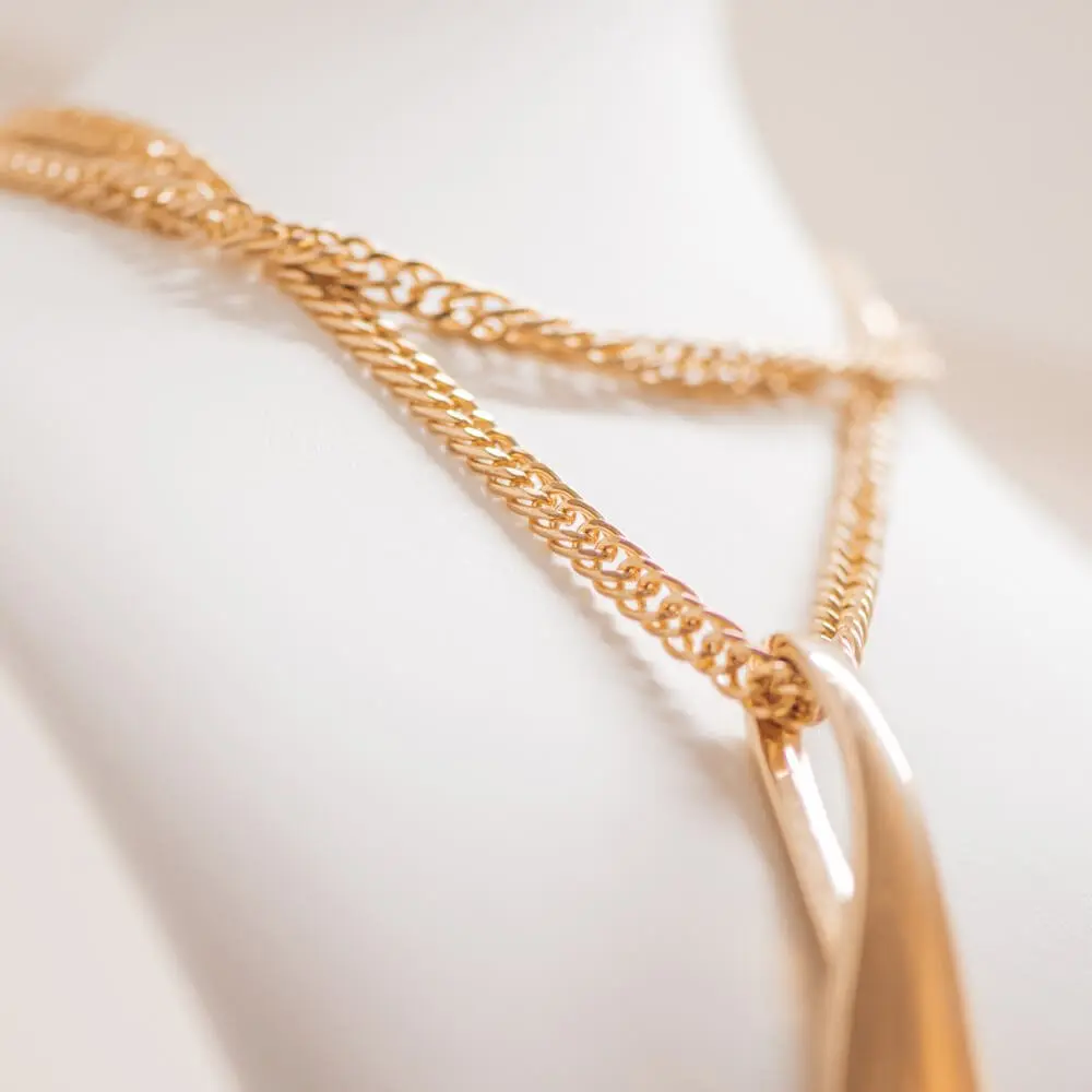 Gold chain draped over a soft surface