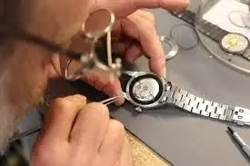 Watchmaker working on a watch with a magnifier