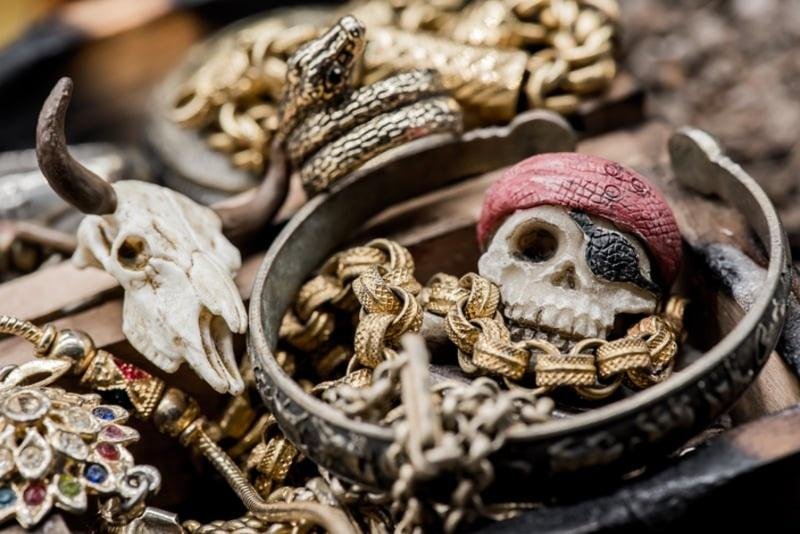 A close-up view of bold, custom accessories including thick gold chains and unique skull pendants, representing the edgy, authentic style of Real Hip Hop Jewelry available from a top Hip Hop Jeweler Little Rock.